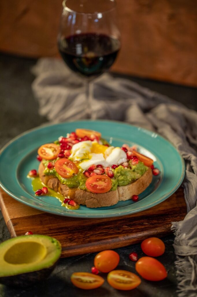 Avocado toast with poached egg, tomatoes and pomegranate at Atez in Manhattan, New York