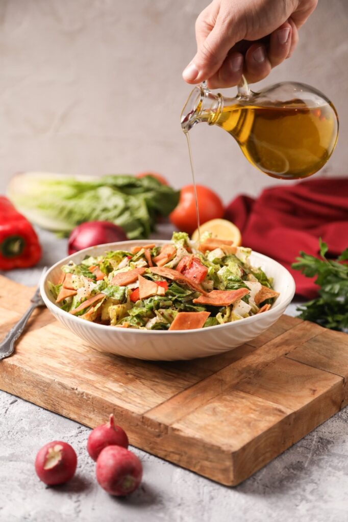 Olive oil poured over fattoush salad at Darna in Paterson, NJ