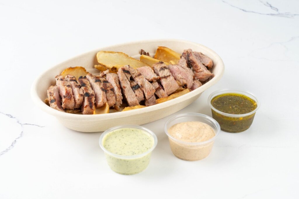 Grilled steak bowl with potatoes and three sauces at Dukes Steaks & Wings in Paterson, NJ