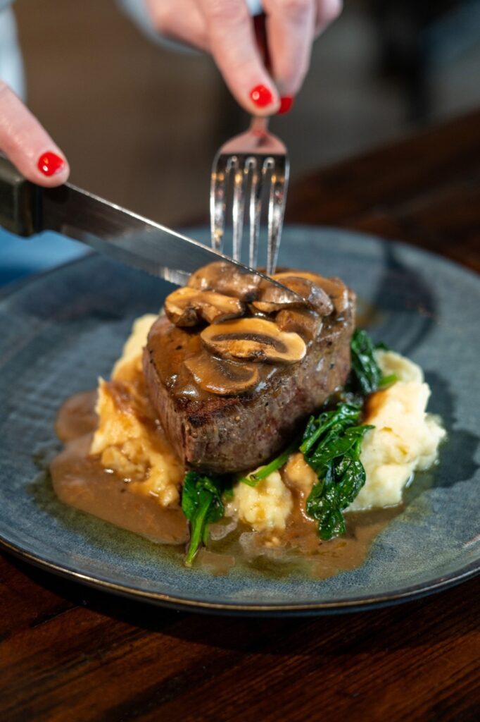 Filet mignon with mushroom sauce being cut at Taphouse Grille in Hackettstown, NJ