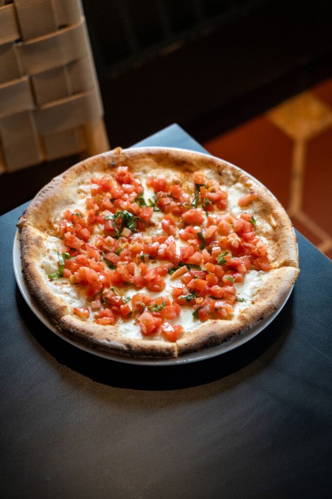 Brick oven bruschetta pizza with tomato and basil at Tiffany in Manhattan, New York