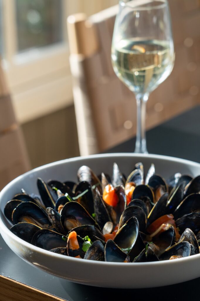 Steamed mussels with tomato and a glass of white wine at Tiffany in Manhattan, New York